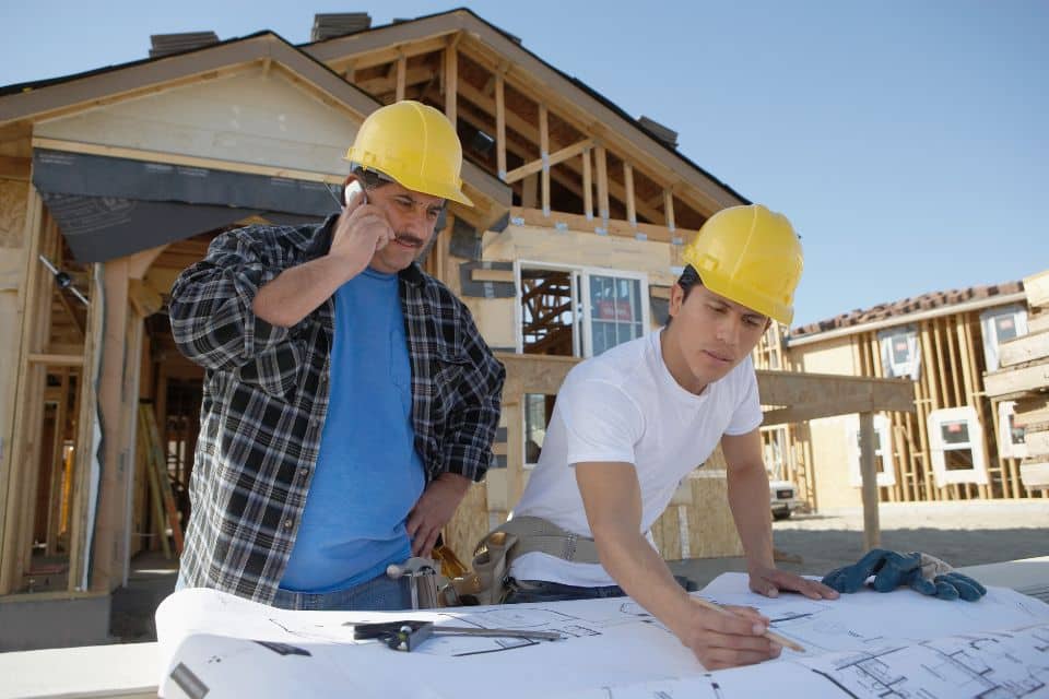 Builders reviewing plans on a construction site